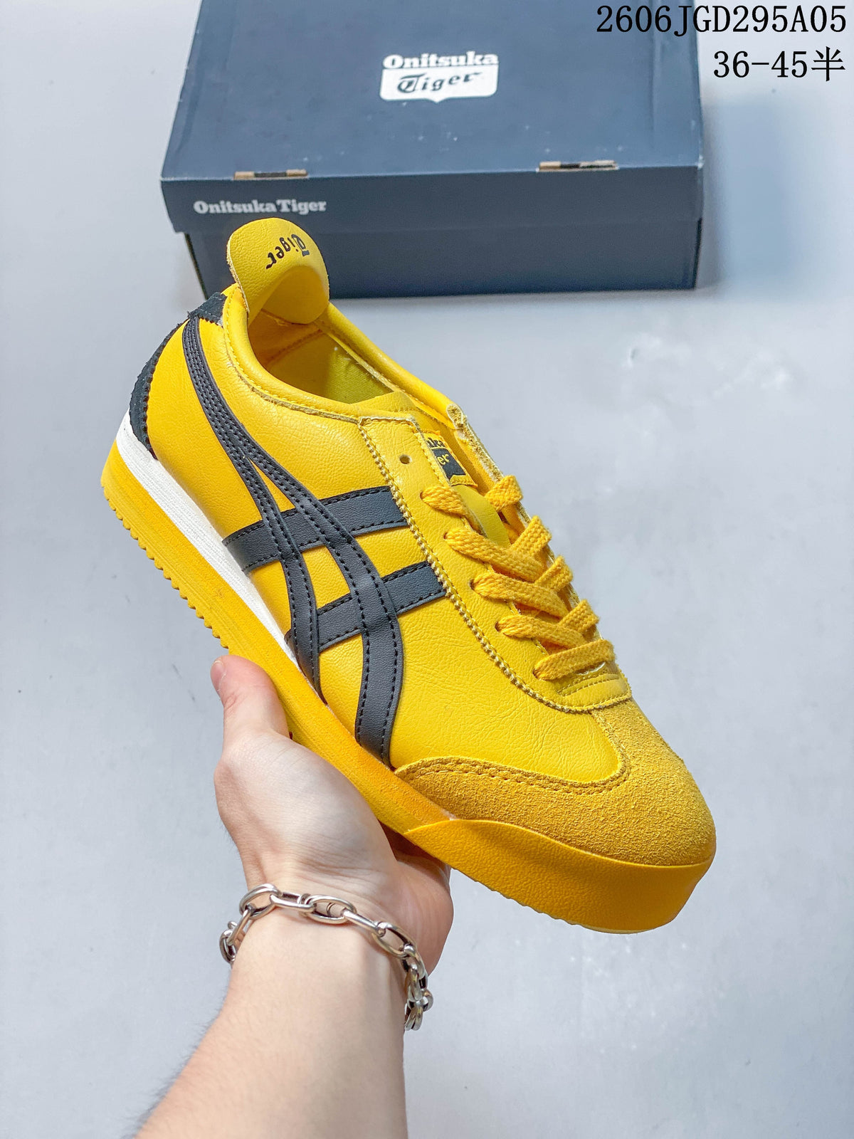 Yellow low-top sneaker with dark gray side stripes