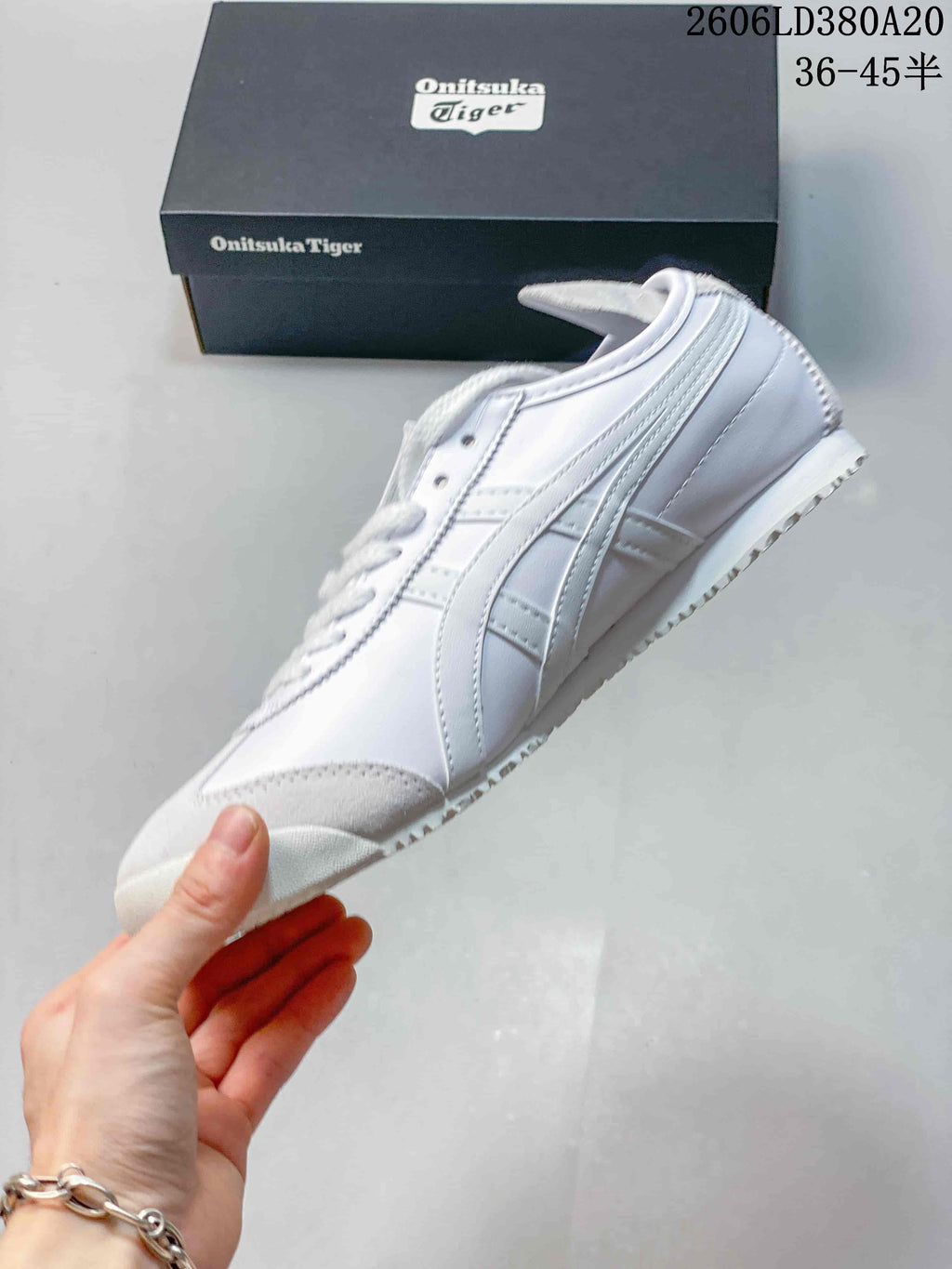 Side view of a white Onitsuka Tiger low-top sneaker with gray accents