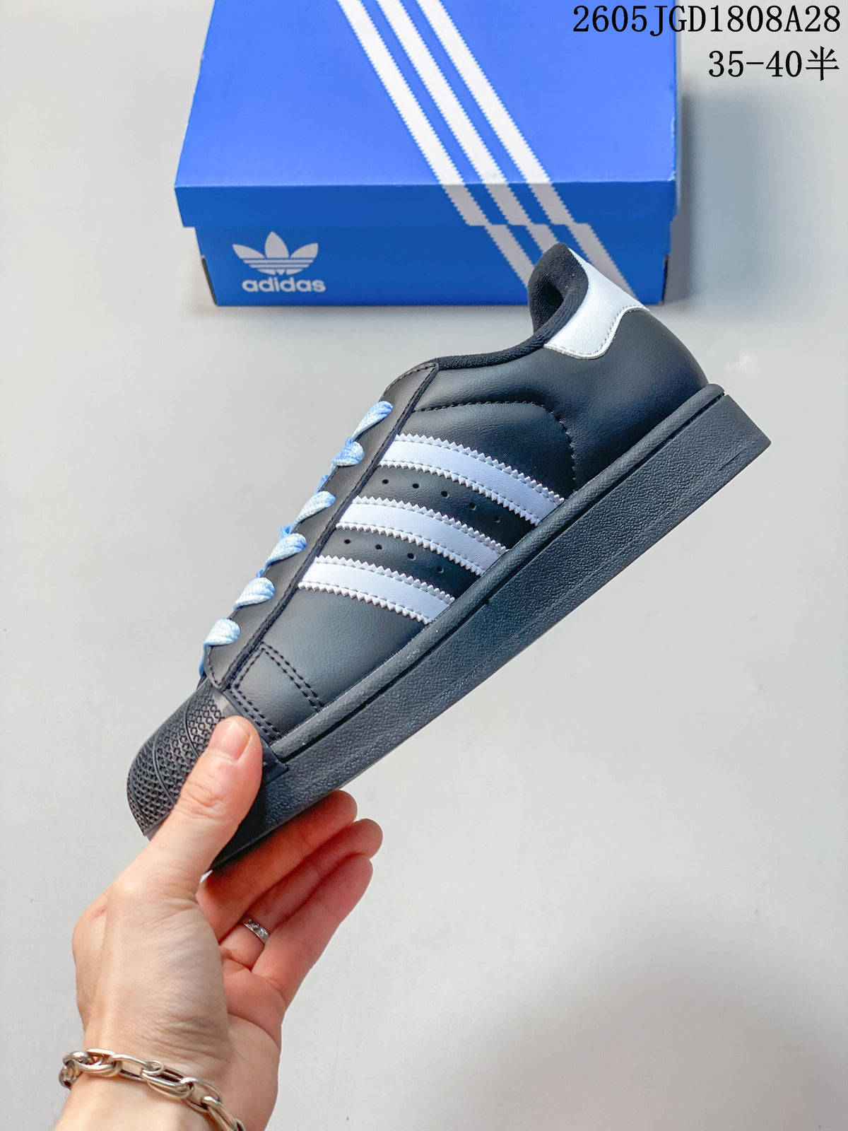 Side profile showing white-and-blue stripes, light blue laces, and a textured shell-style toe