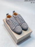 Pair of grey lace-up sneakers with studded toes and red outsole styling