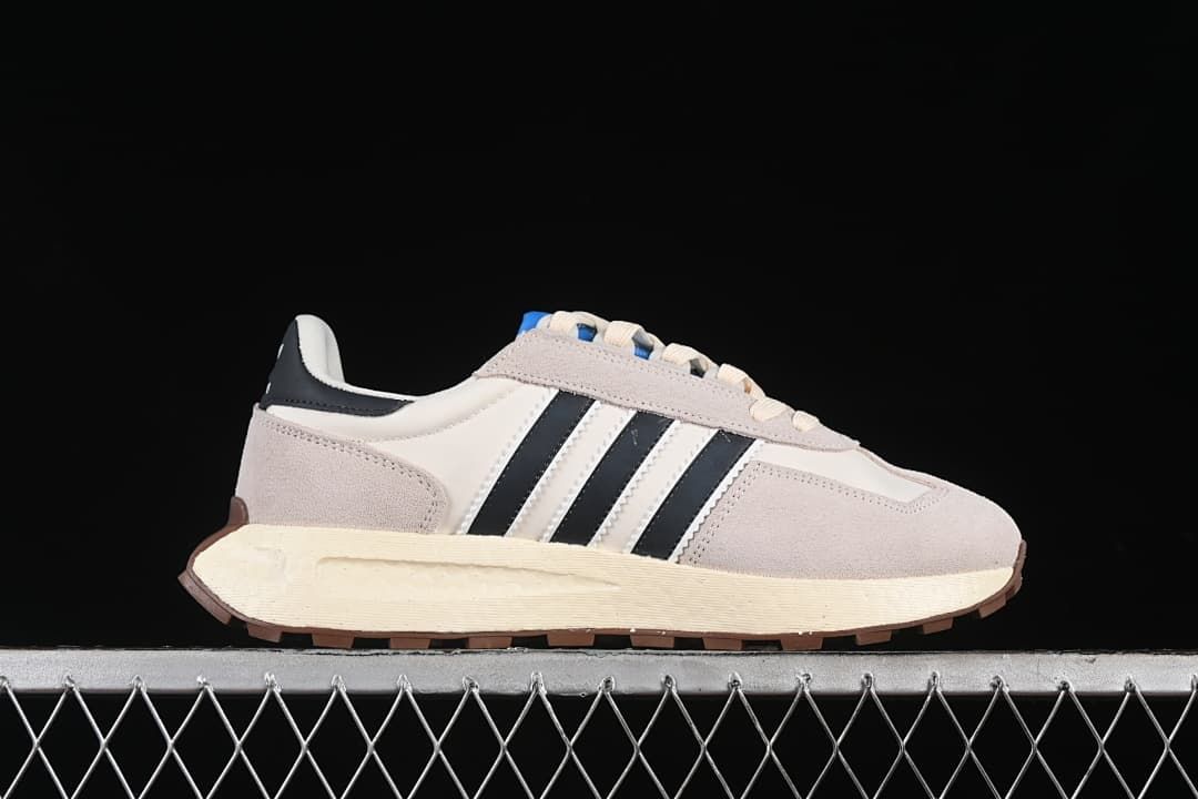 Side profile of the sneaker with light gray overlays, black stripes, and cream midsole.