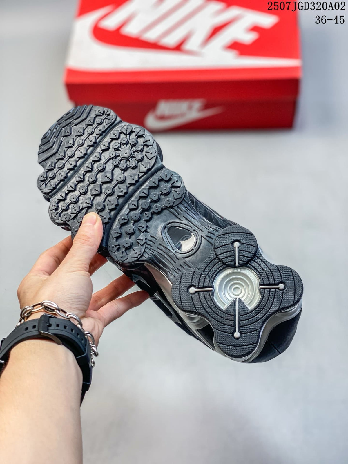 Underside of a black Nike Shox TL sneaker showing its patterned outsole