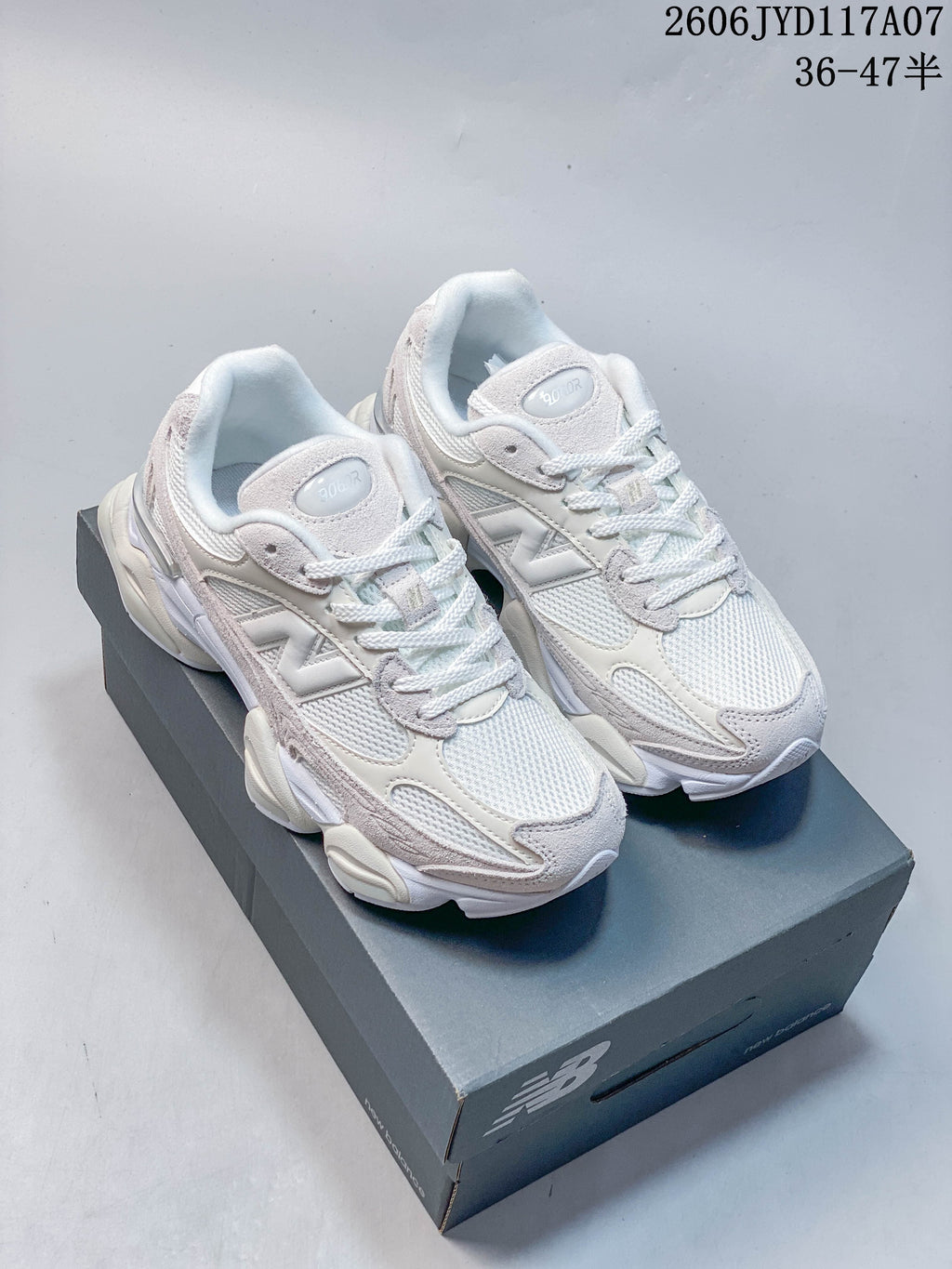 Pair of white and pale grey New Balance 9060R sneakers on a box