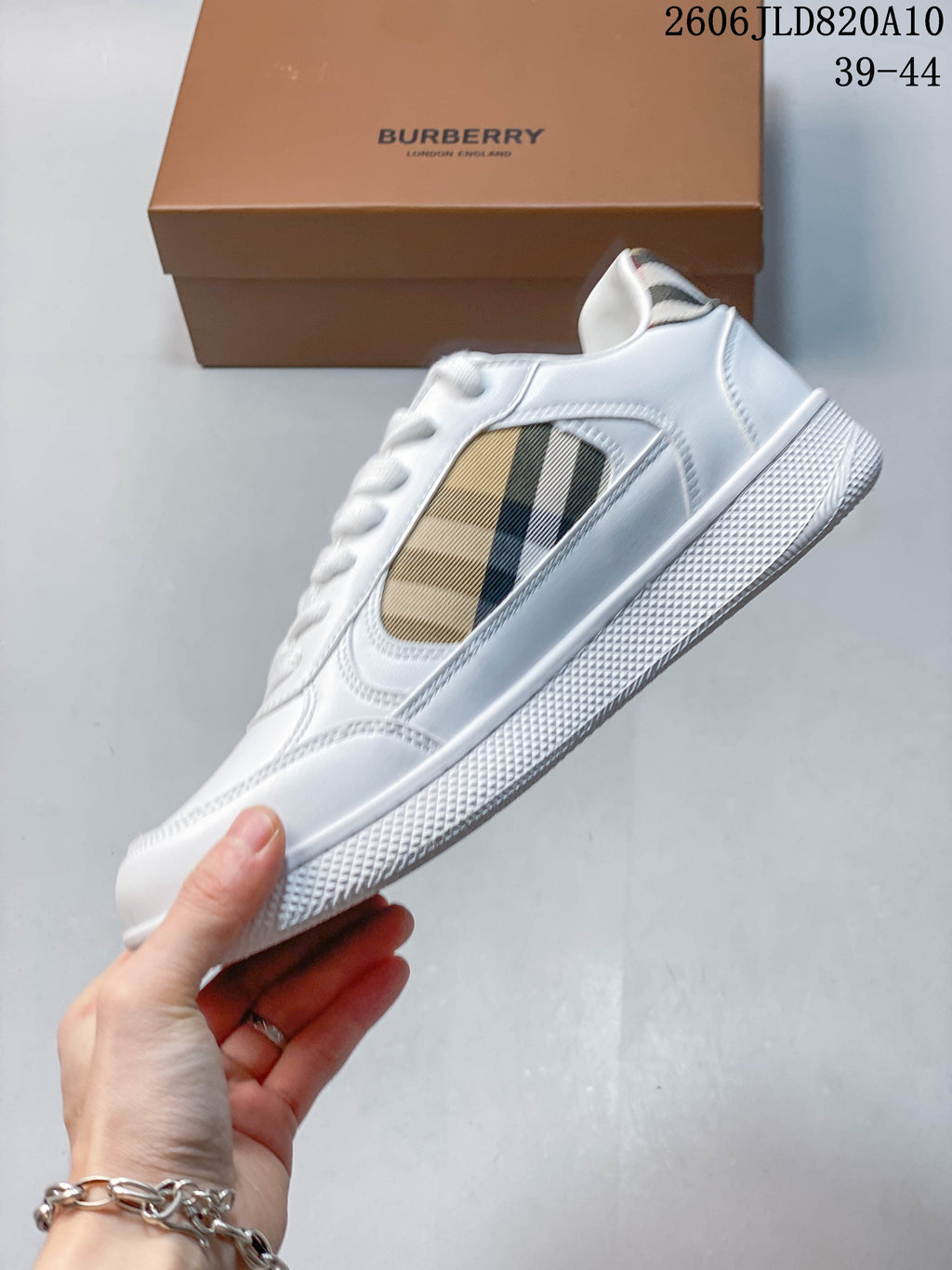 Side view of a white low-top sneaker with beige check-pattern panel and textured sole