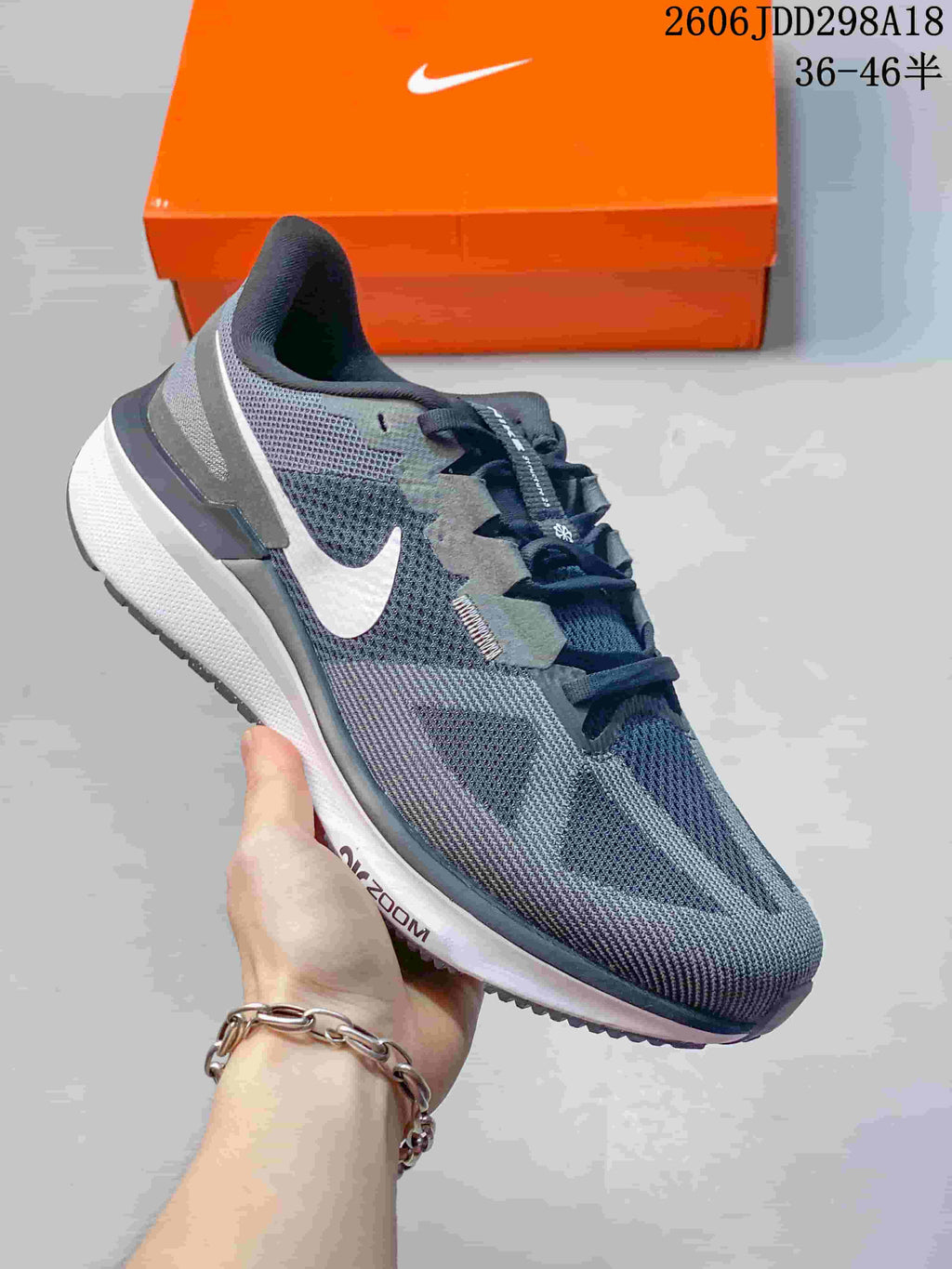 Side view of a grey Nike running shoe with dark laces and a white midsole