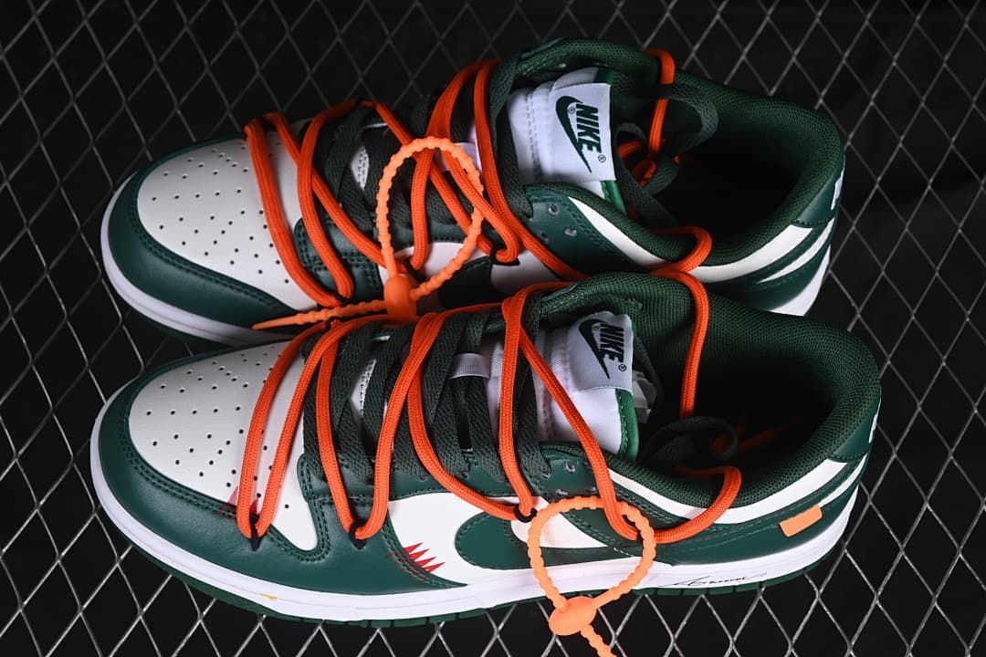 Pair of green and white low-top sneakers with orange laces