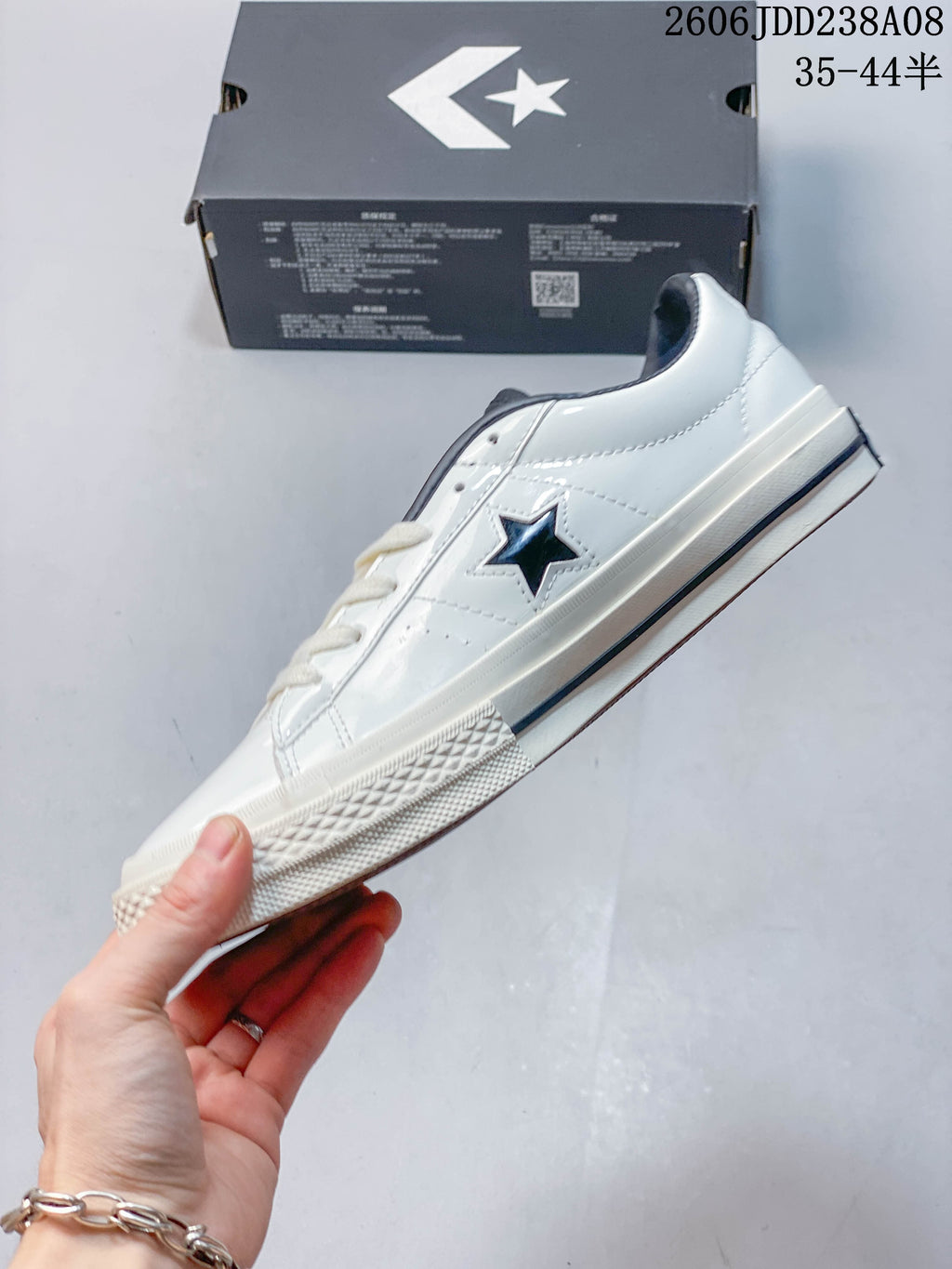 Side view of a white low-top Converse One Star sneaker with dark star detail