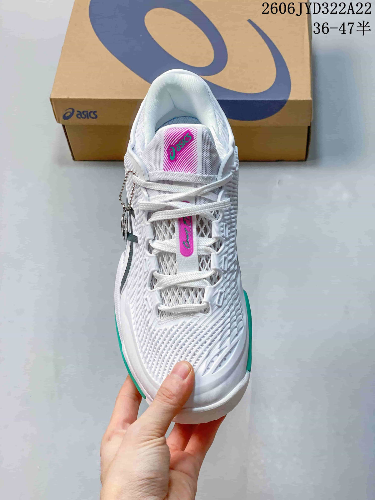 Top view of a white lace-up ASICS tennis shoe with a patterned upper and magenta tongue label.