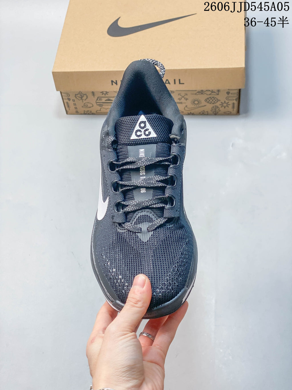 Top view of the laces and tongue on a dark gray Nike Pegasus Trail 6 shoe.