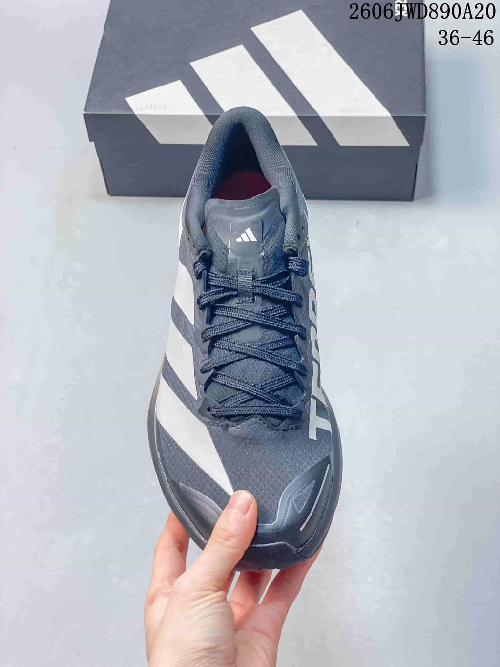 Front view of the gray lace-up trail shoe with white side stripes
