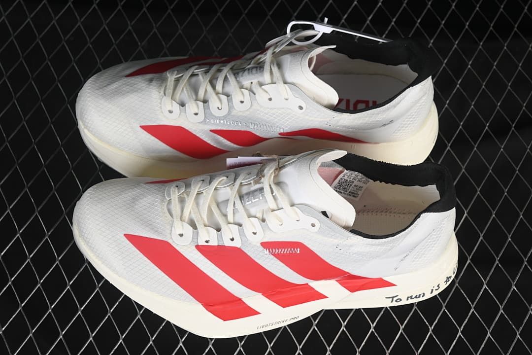 Pair of white and red adidas Adizero running shoes shown from above