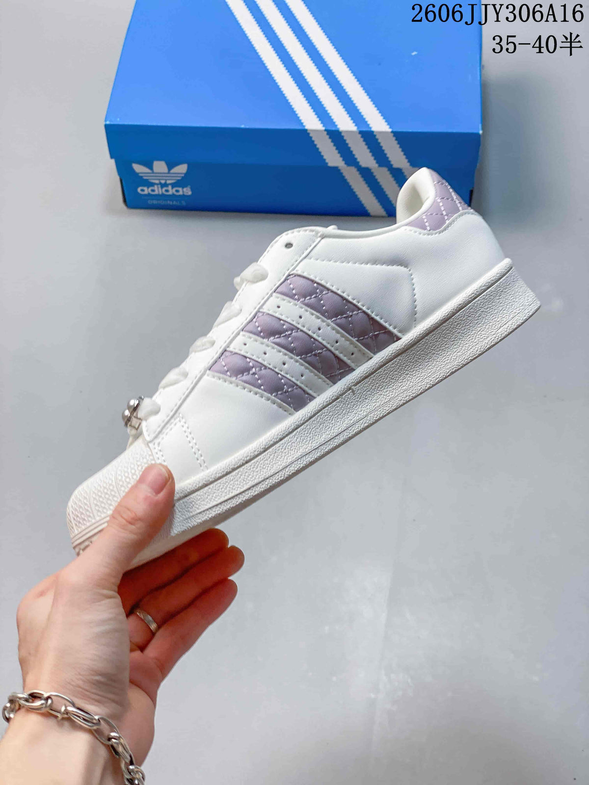 Side view showing the white upper, lilac quilted stripes, and textured sole