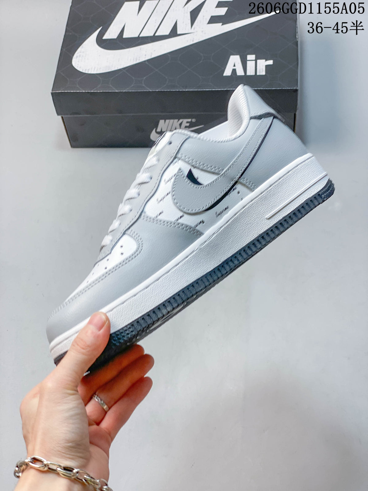 Side view of a gray and white low-top sneaker with repeated lettering and a dark outsole