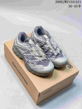 Pair of silver and gray Salomon XT-Quest ADV sneakers on a shoebox; image overlay shows a size range.