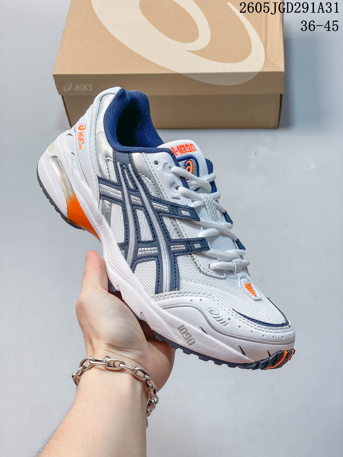 Angled view highlighting the sneaker's white upper, navy side overlays, and orange details.