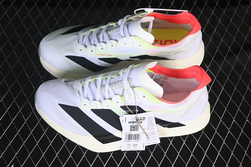 Pair of white Adidas running shoes with black stripes and coral heel lining.