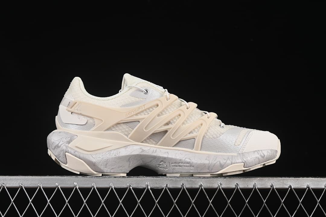 Side profile of the shoe showing the pale frame and patterned midsole.