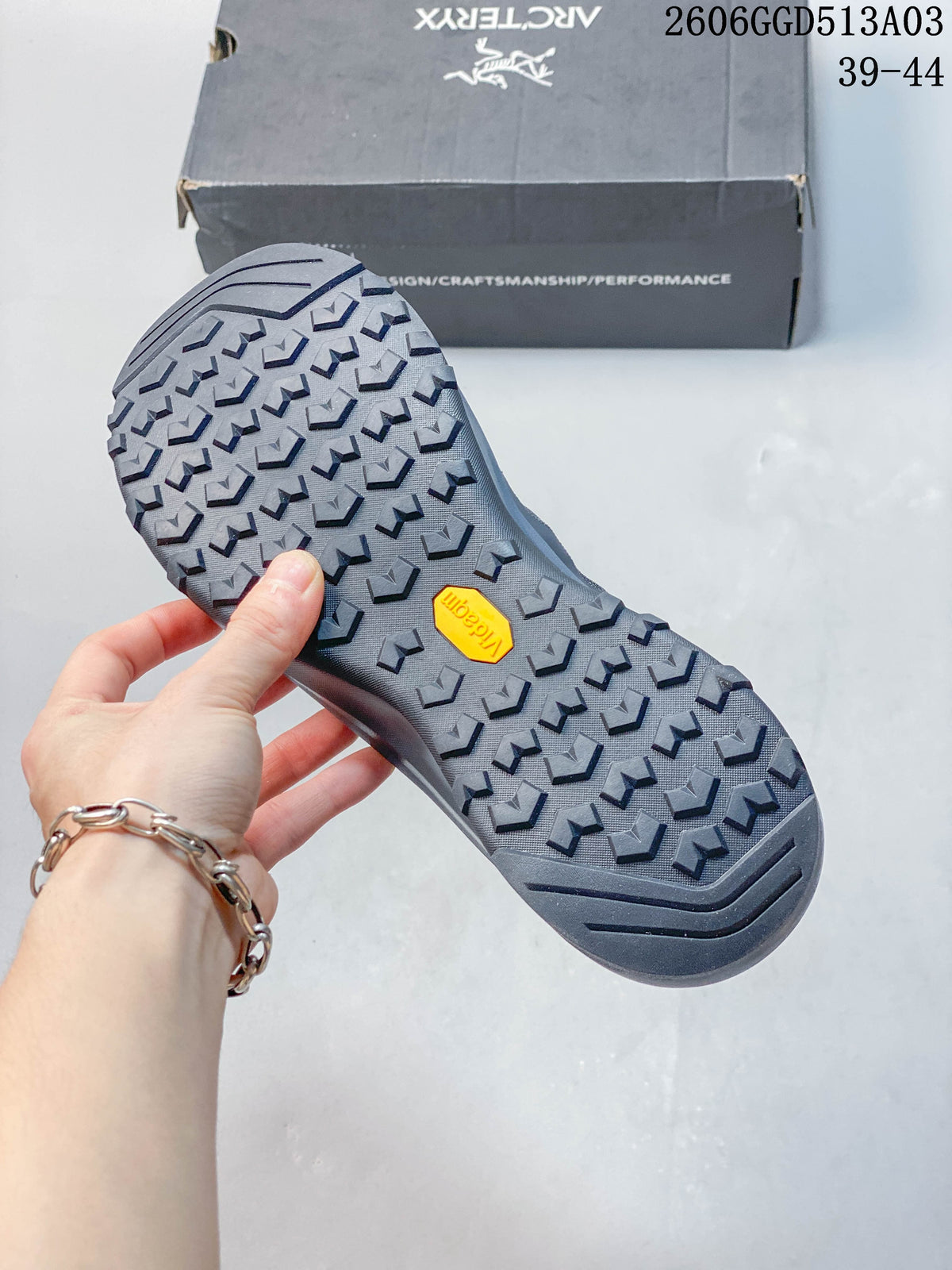 Close-up of the lugged outsole with Vibram branding on a gray-blue outdoor shoe.