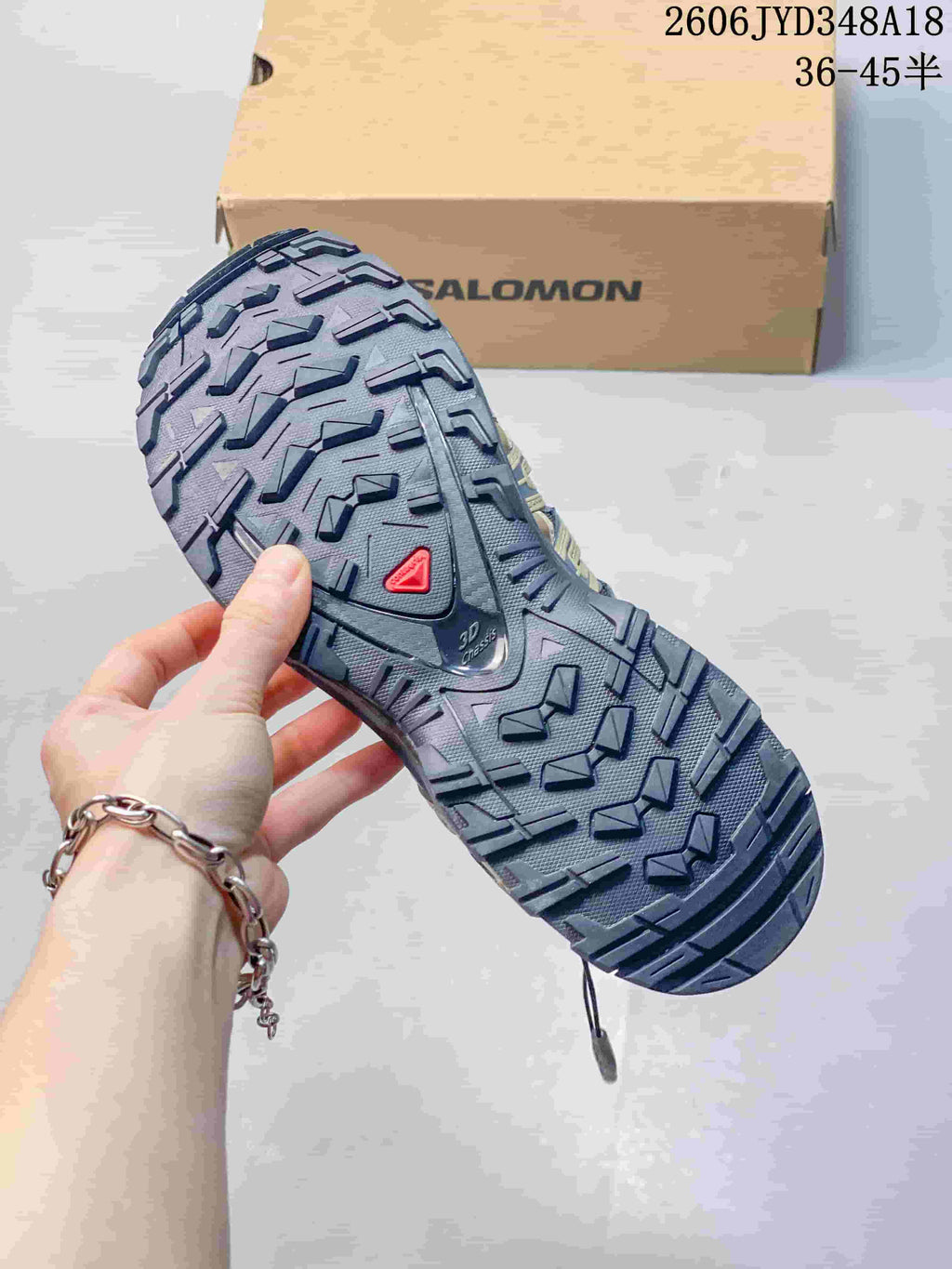 Close-up of the Salomon XT-3D shoe's deep-tread outsole; image also displays a size range.