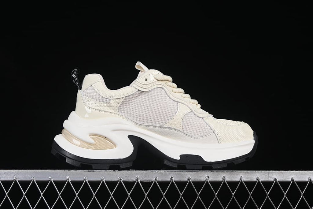 Side profile showing the beige upper and sculpted platform-style sole