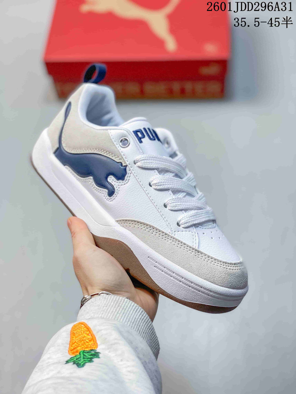 Side view of a white PUMA 180 sneaker with a navy side detail