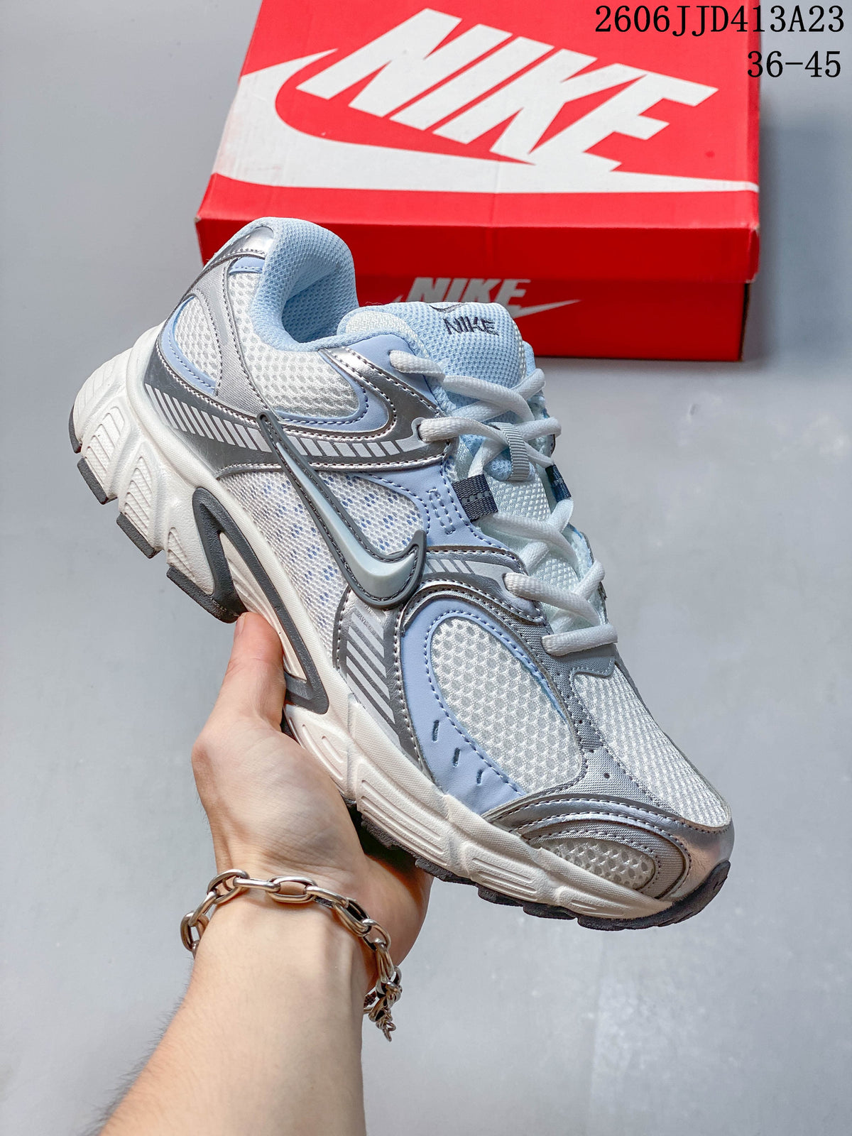White and pale blue Nike Air Zoom Winflo 12 sneaker shown with a red shoe box.