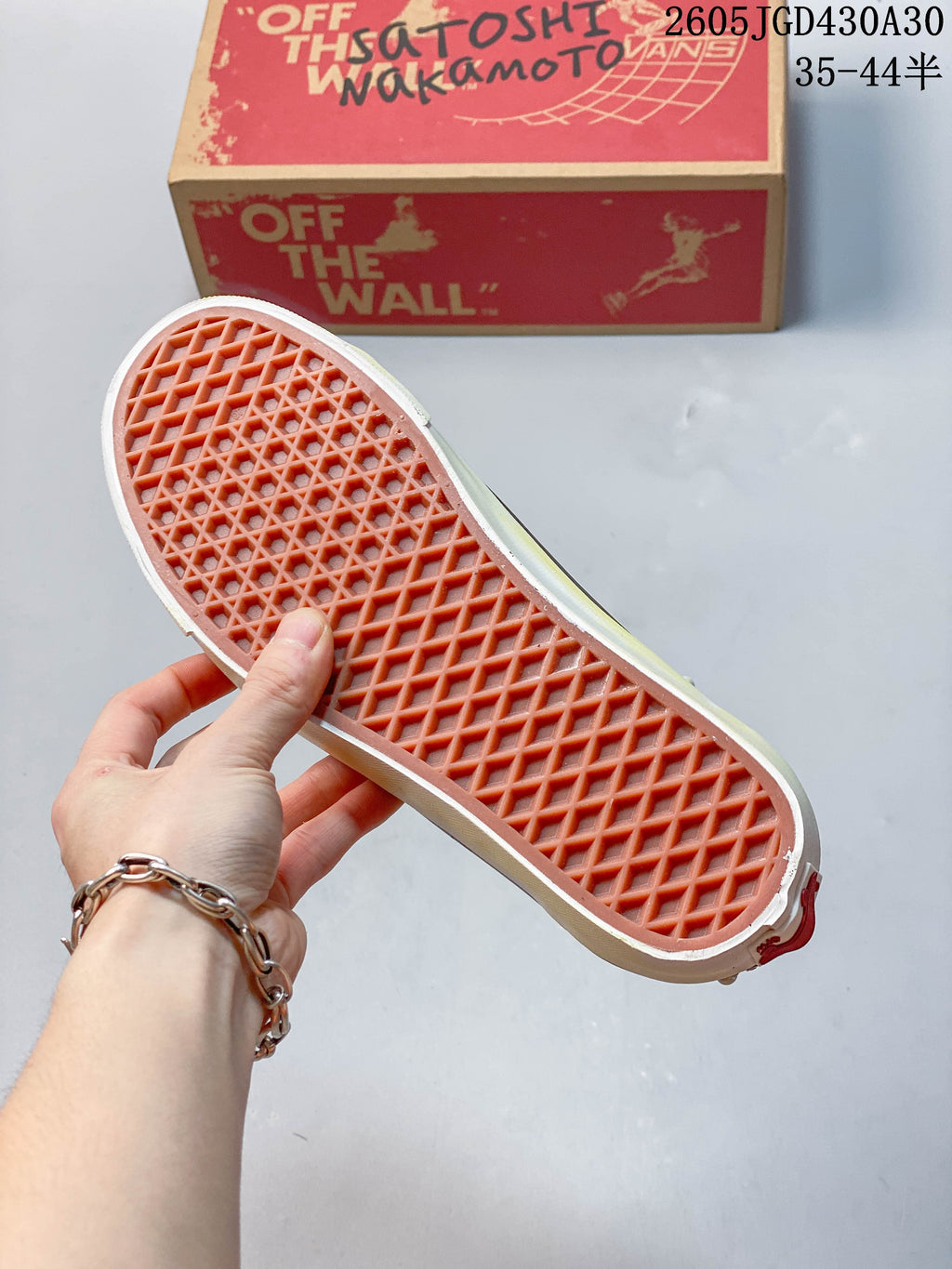 Waffle-pattern outsole of a Vans sneaker, with a shoebox in the background.