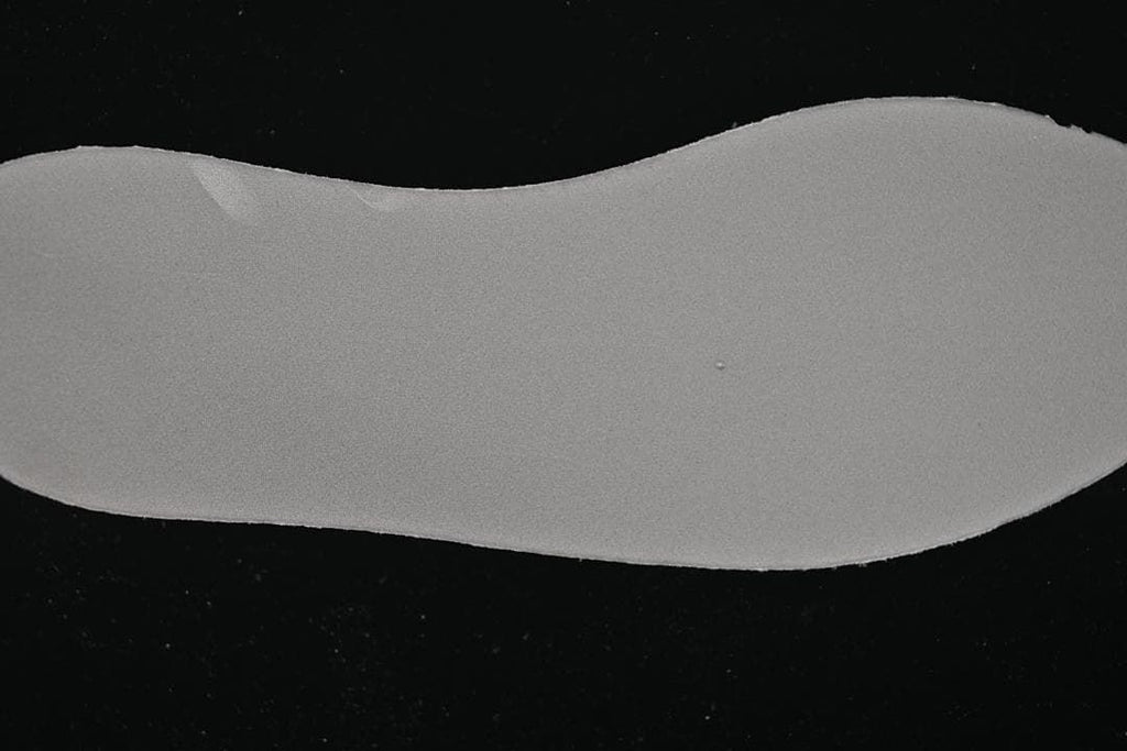 Plain gray shoe insert displayed against a dark background