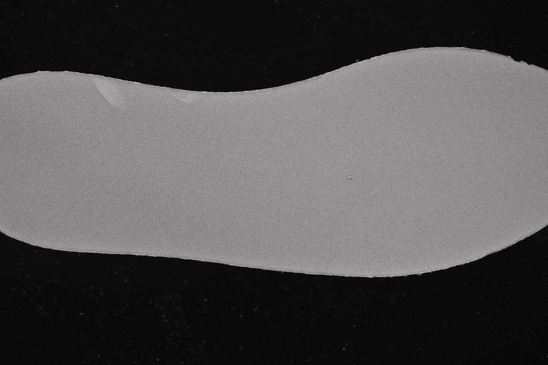 Plain gray shoe insert displayed against a dark background