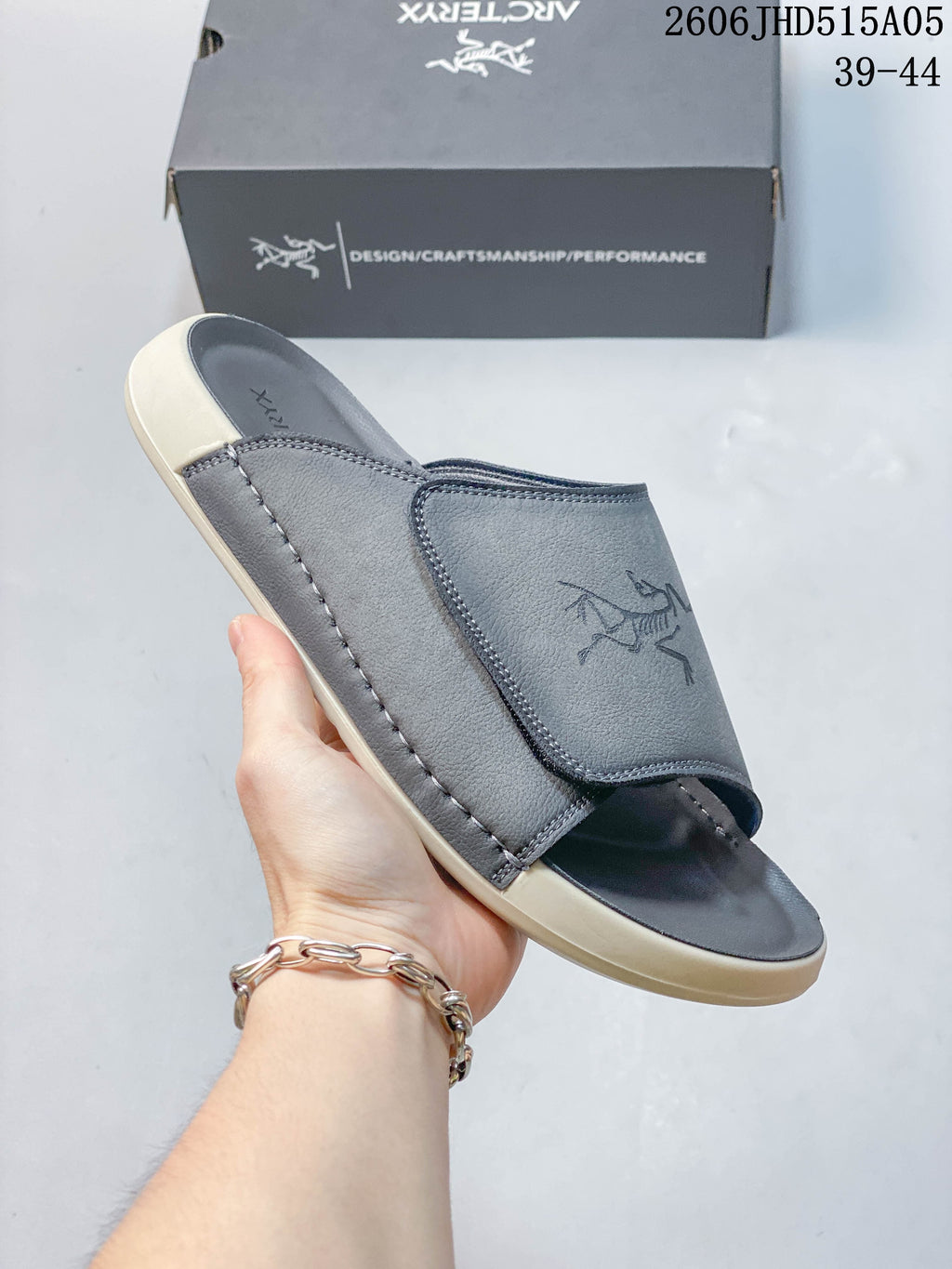 Close-up of a gray slide sandal showing its wide strap and stitched detailing.