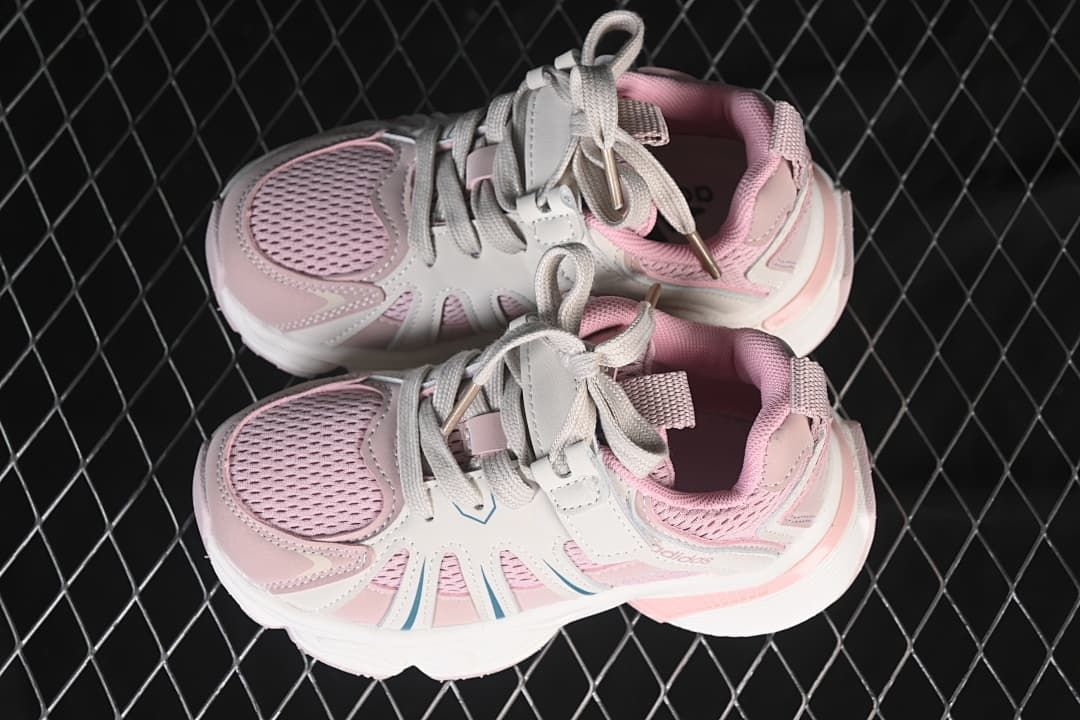 Pair of pink and off-white kids sneakers viewed from above