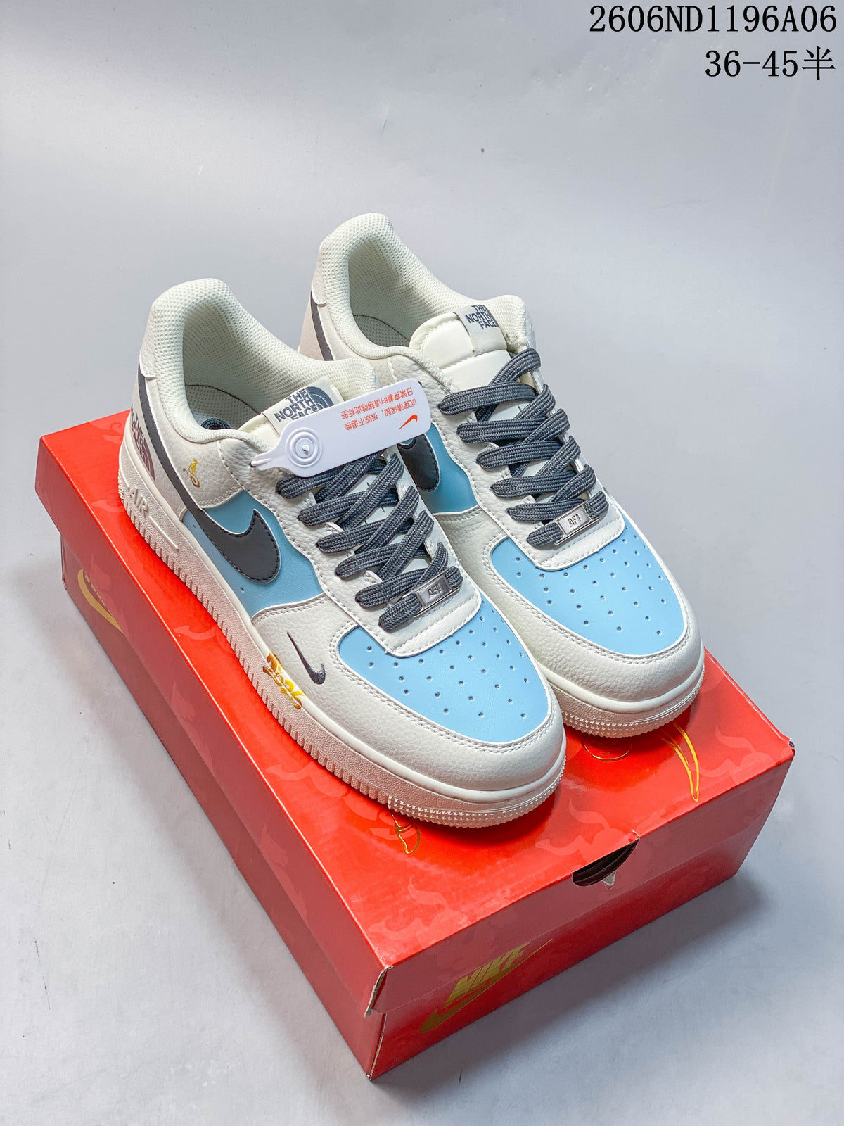 Pair of light blue, off-white and dark gray low-top sneakers with horse-themed details on a red box