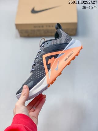Side view showing the orange Swoosh, layered midsole, and visible ReactX marking near the heel.