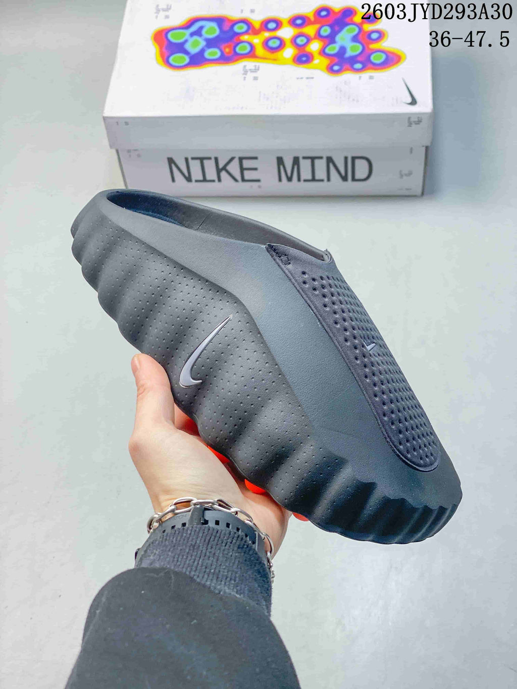 Side profile of a dark gray Nike Mind slide with a small Swoosh
