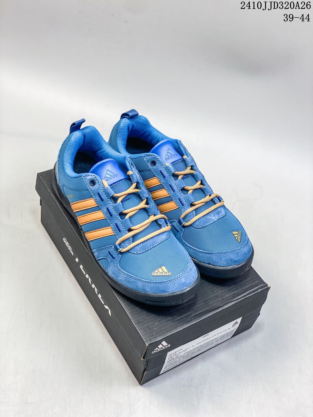 Blue adidas Daroga Plus shoes with orange stripes, shown on a shoebox.