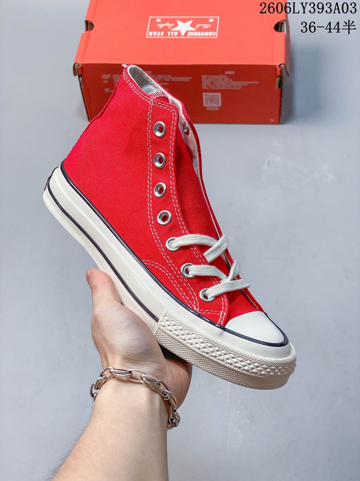 Red high-top sneaker with white laces and rubber toe cap