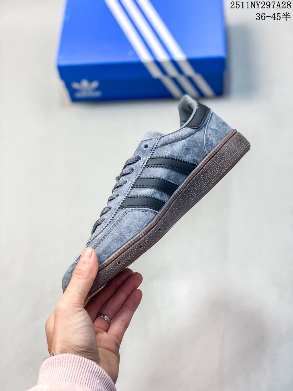 Side view of the gray sneaker with black stripes and brown outsole