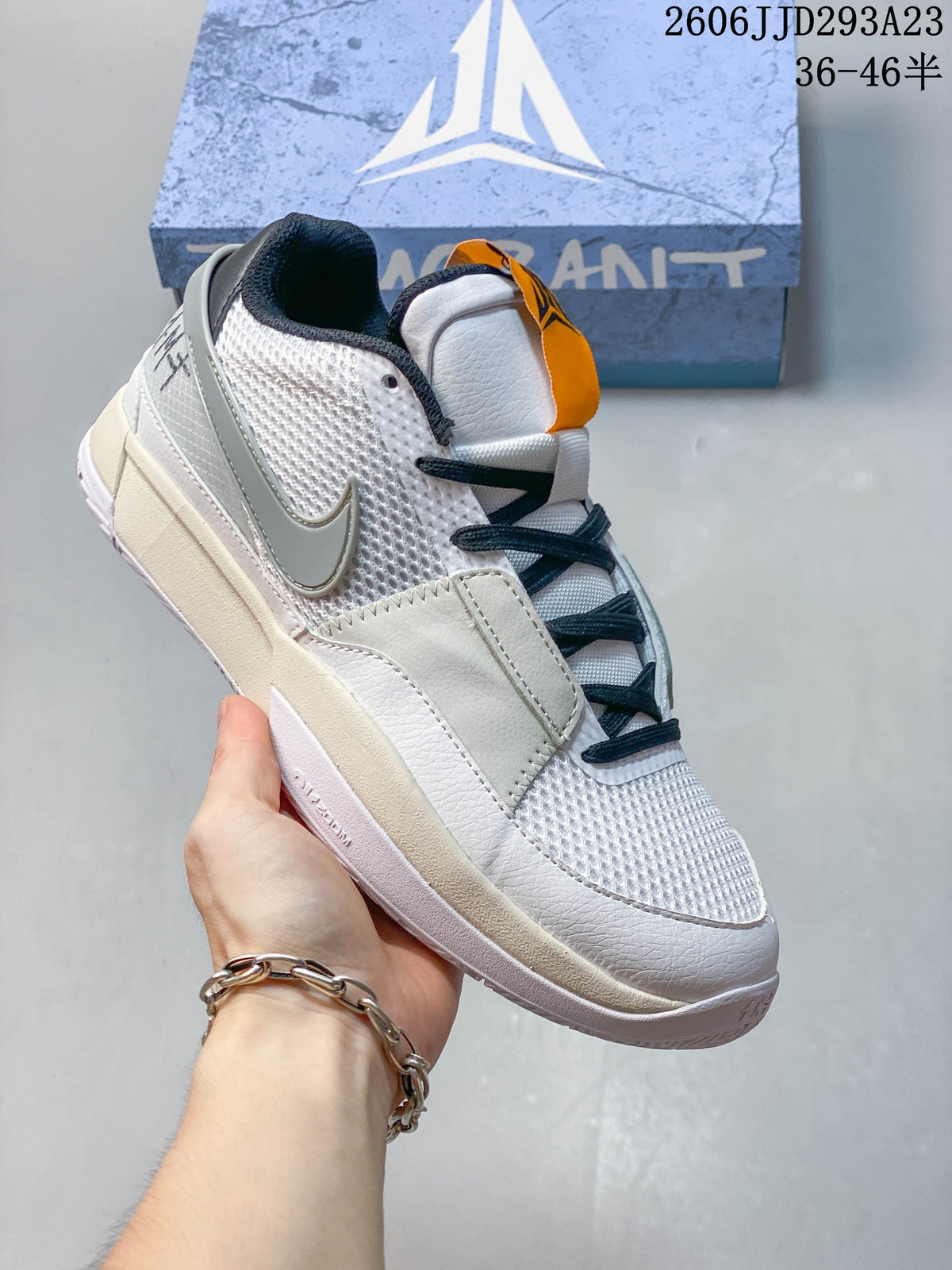 Angled side view of the white and gray Ja 1 EP shoe.