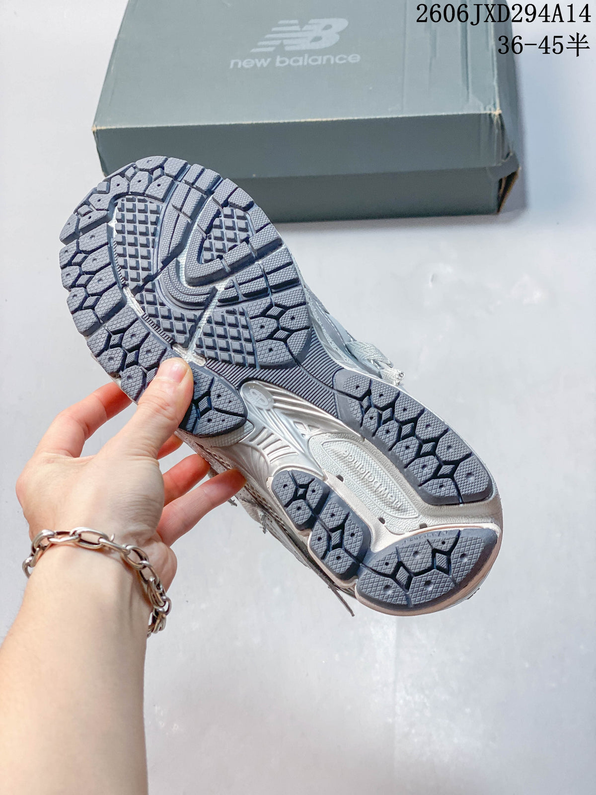 Outsole view of a silver-grey New Balance 1906 sneaker.