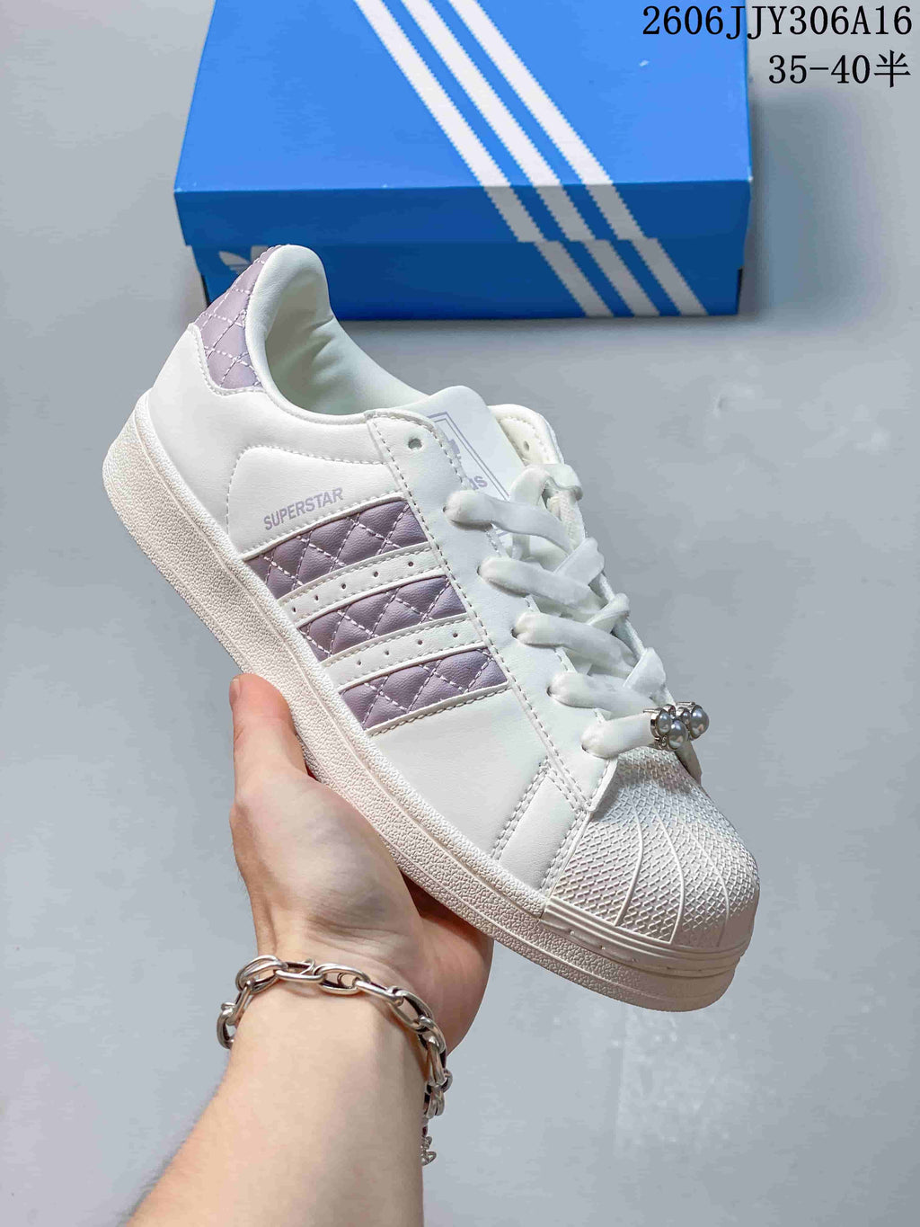 Angled view of the white Superstar II sneaker with lilac accents