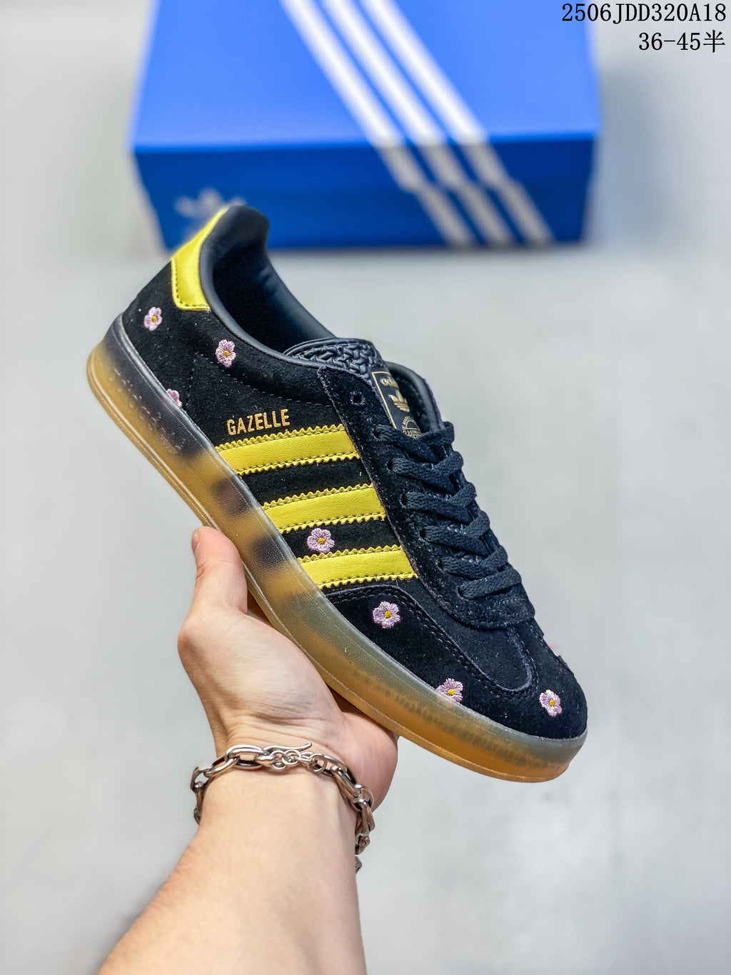 Black Adidas Gazelle low-top sneaker with yellow stripes and small floral details