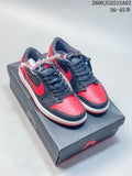 Pair of black and red low-top sneakers on a shoebox, shown from above