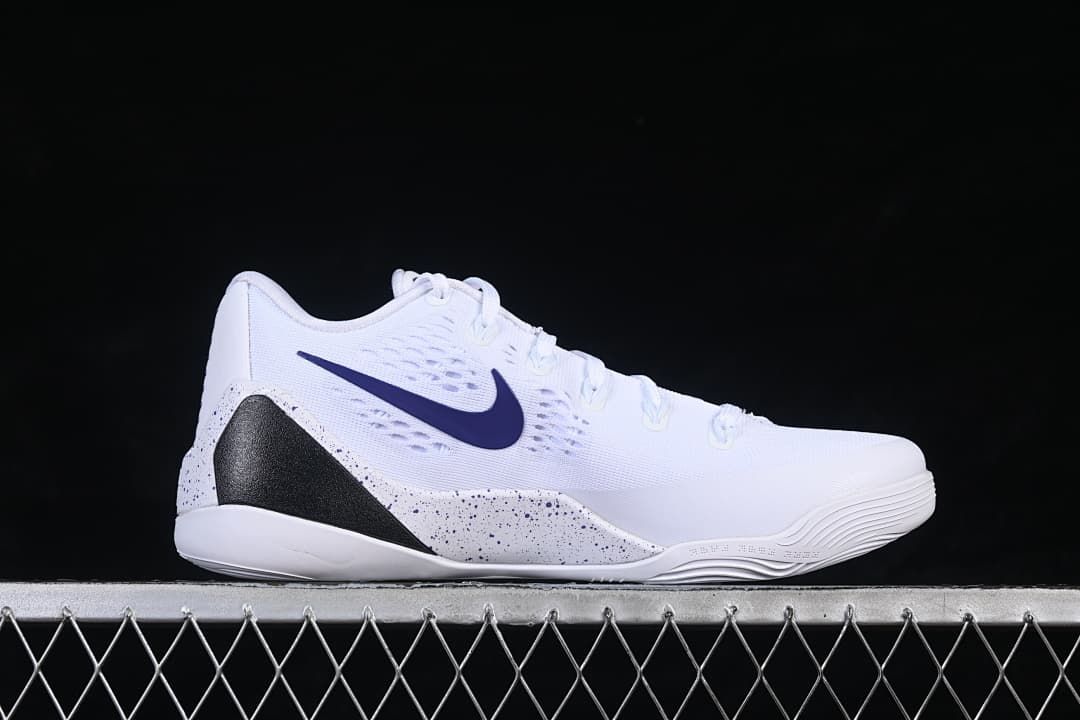 Side view of a white shoe with purple swoosh and black speckled accents