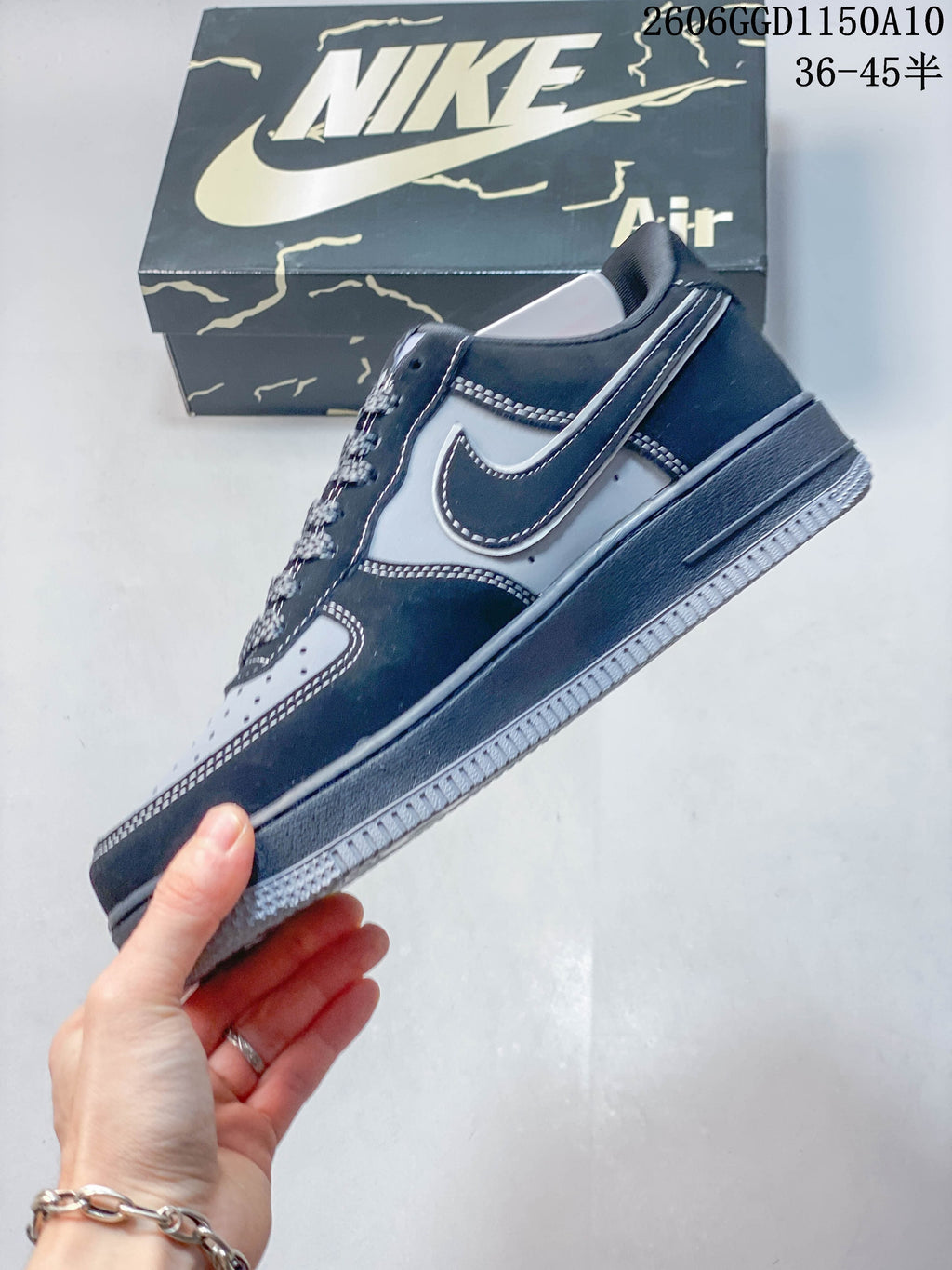 Side profile of a navy and gray low-top sneaker with contrast stitching and a dark midsole