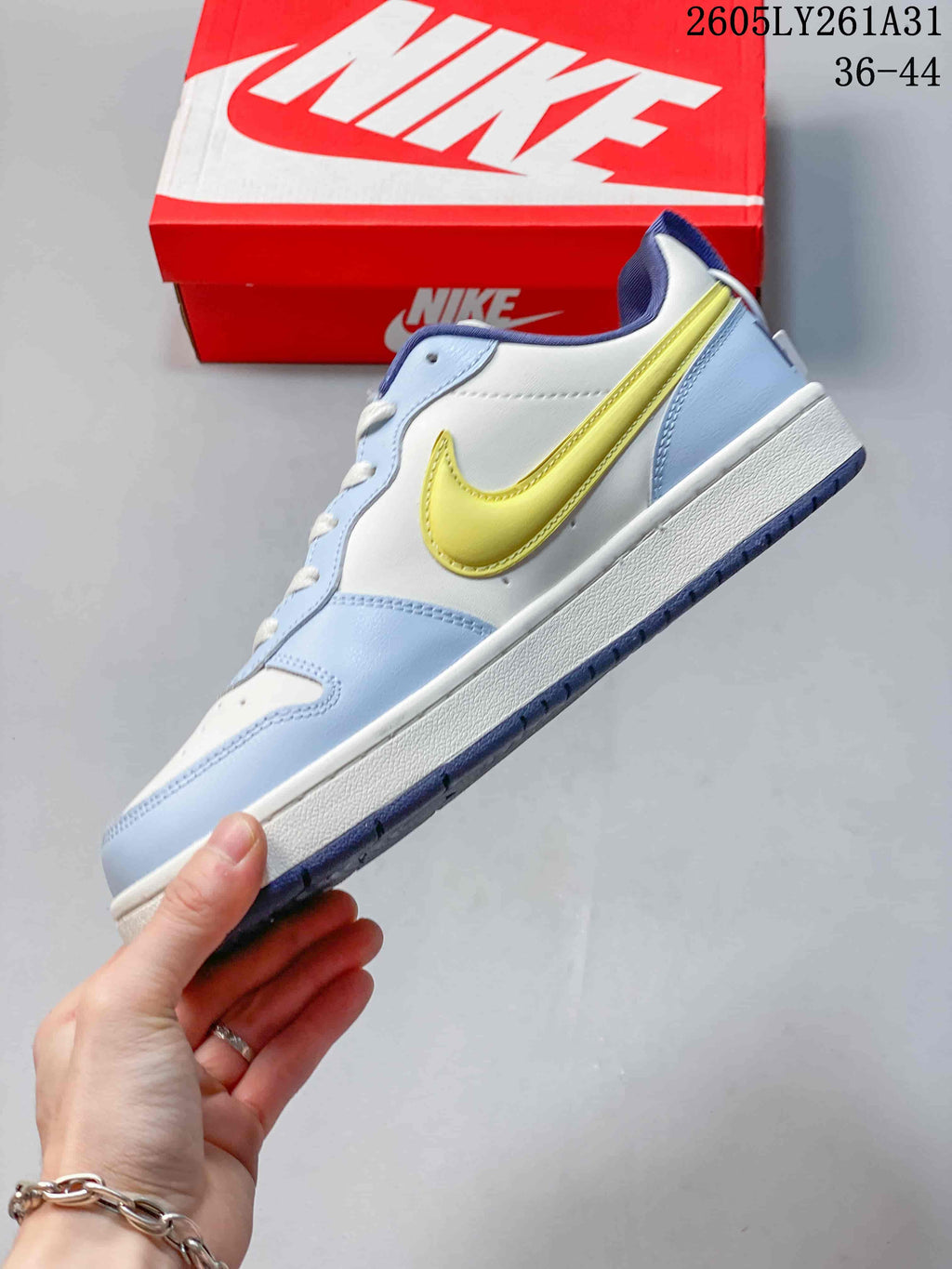 Side profile of the low-top sneaker with light blue overlays and a yellow Swoosh