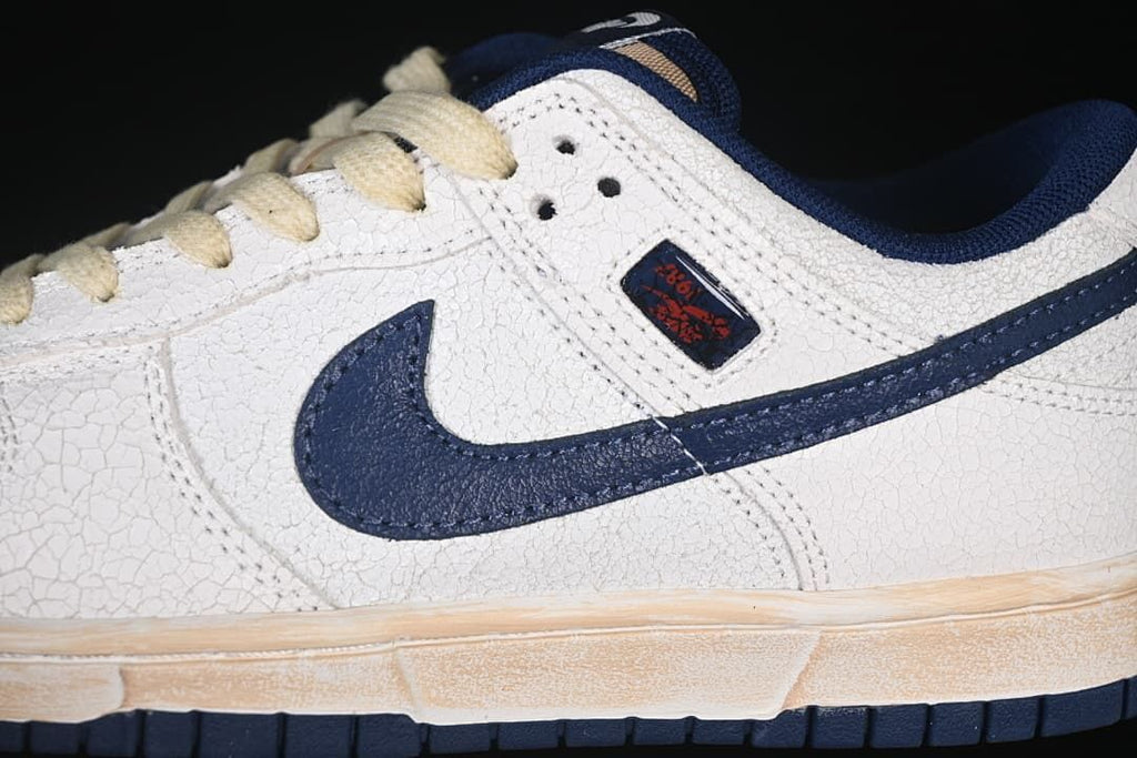 Close-up of navy Swoosh, textured off-white upper, and side label