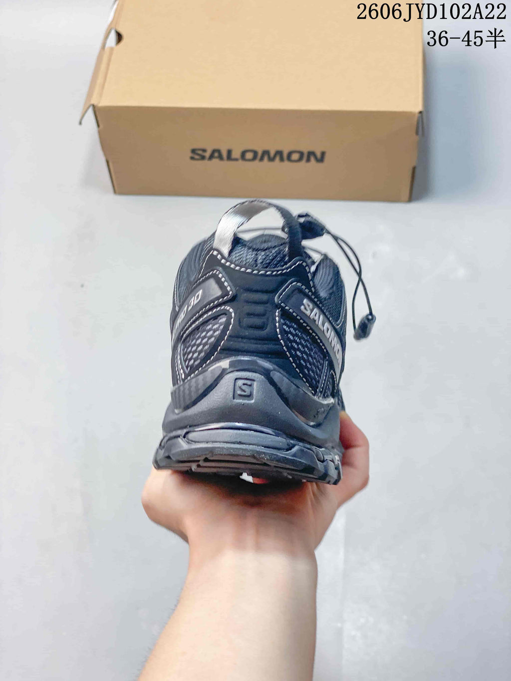 Rear view of a dark gray Salomon XA Pro 3D shoe with heel loop and branding.