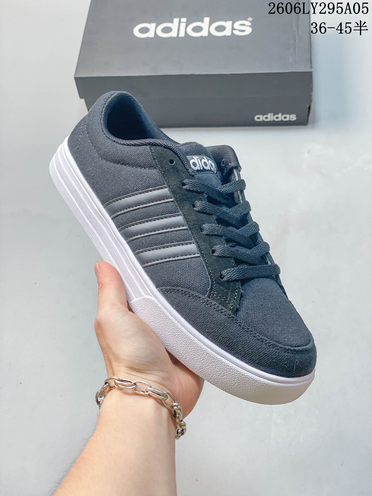 Angled side view of the dark gray sneaker with three stripes and white sole