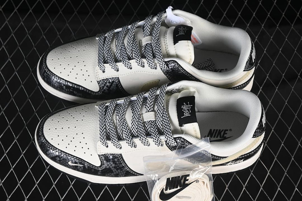 Top view of the Nike SB Dunk Low pair with patterned laces, perforated toe boxes, and an extra set of light-colored laces.
