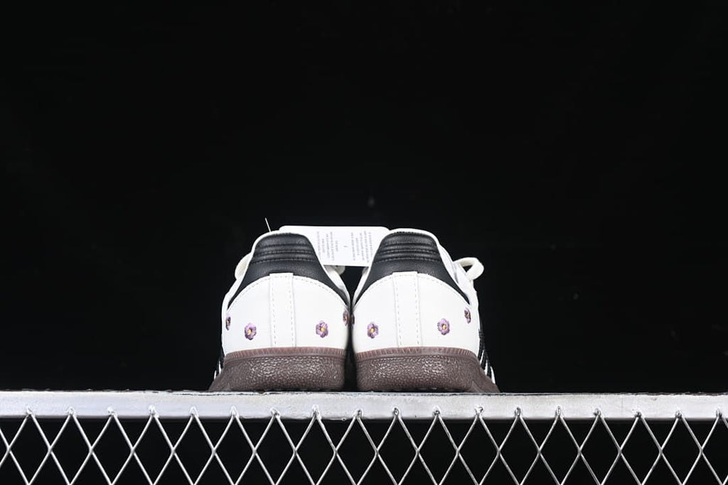 Rear view of both shoes showing black heel tabs and floral embroidery